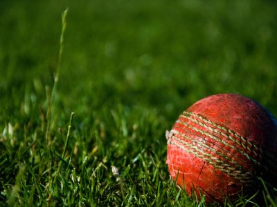 A close-up of a cricket ball on a field
