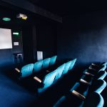 Vintage turquoise cinema seats facing a blank white screen