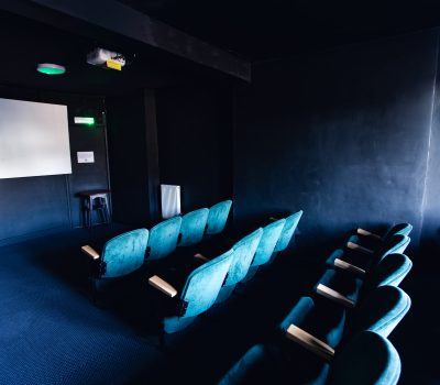 Vintage turquoise cinema seats facing a blank white screen