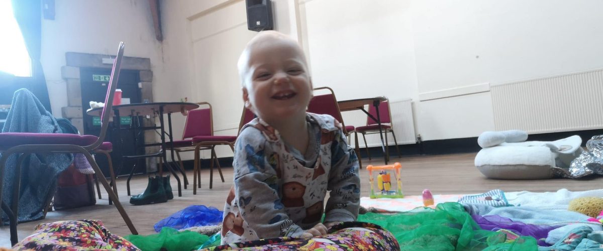 Image of baby in the Hall at the Gregson Centre smiling