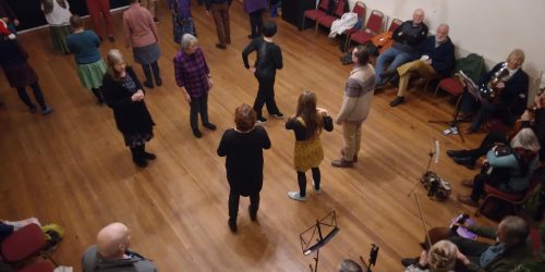 From above: A group of people dance to live music