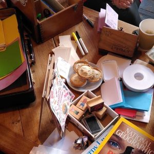 A table with craft and zine-making supplies coverin it