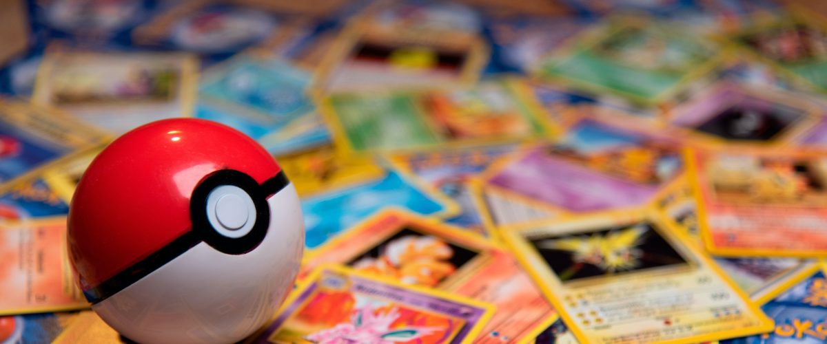 A pokeball sits on a table of pokemon cards